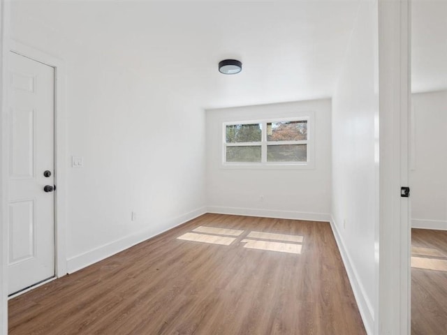 unfurnished room featuring baseboards and wood finished floors