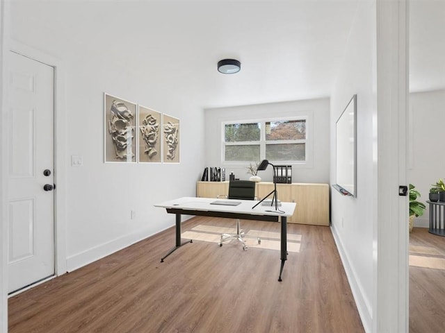 office space featuring baseboards and wood finished floors