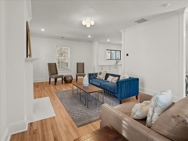 living area with baseboards, visible vents, wood finished floors, and recessed lighting