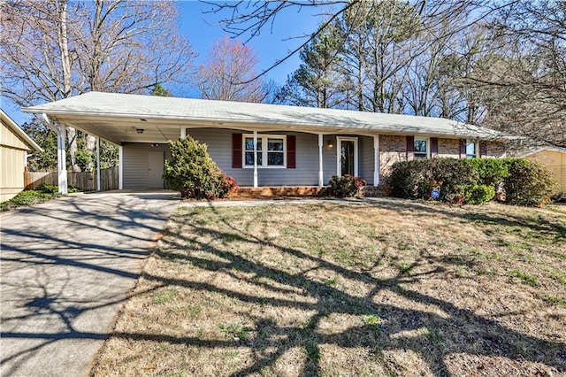 single story home with driveway, fence, a front lawn, and an attached carport