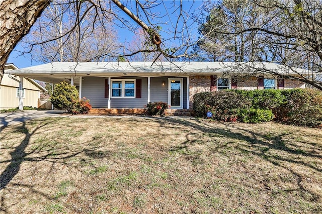 single story home with an attached carport, brick siding, driveway, and a front lawn