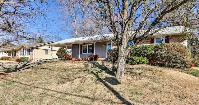 ranch-style home with covered porch and a front lawn