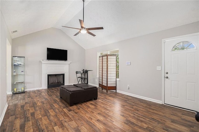 28 Fawn Ct, Sharpsburg, GA 30277 - living room with a ceiling fan, dark wood-style floors, lofted ceiling, a fireplace, and a textured ceiling