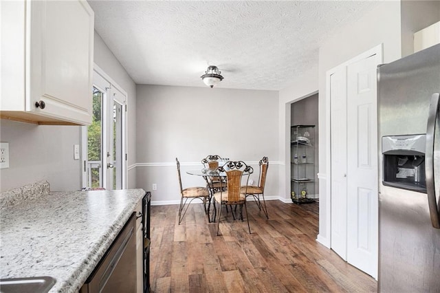 28 Fawn Ct, Sharpsburg, GA 30277 - kitchen featuring appliances with stainless steel finishes, wood finished floors, a textured ceiling, and white cabinets