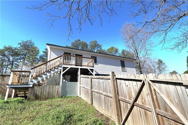 exterior space featuring stairway, fence, and a wooden deck