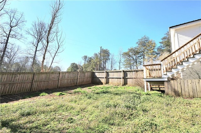 view of yard featuring stairway and a fenced backyard