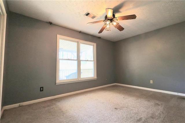 spare room with carpet flooring, baseboards, visible vents, and ceiling fan