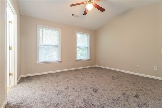 spare room featuring carpet, vaulted ceiling, and ceiling fan