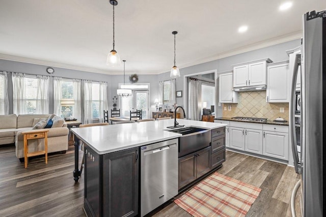 kitchen with dark wood-type flooring, a center island with sink, stainless steel appliances, and white cabinetry