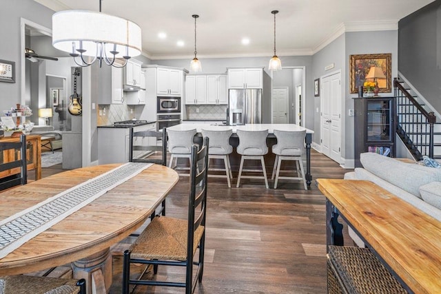 dining room featuring ceiling fan, dark hardwood / wood-style floors, and crown molding