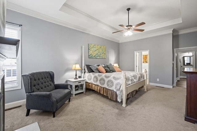 bedroom with a raised ceiling, ceiling fan, crown molding, and ensuite bathroom