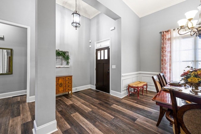 entrance foyer featuring dark hardwood / wood-style flooring, crown molding, and an inviting chandelier