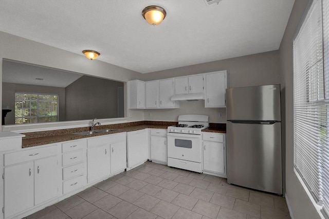 1234 Wellhouse Walk, Stone Mountain, GA 30088 - kitchen featuring freestanding refrigerator, white gas range oven, under cabinet range hood, and dark countertops