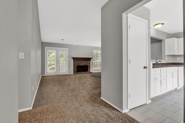 1234 Wellhouse Walk, Stone Mountain, GA 30088 - unfurnished living room with a brick fireplace and light carpet