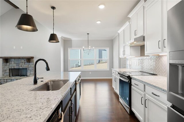 kitchen with white cabinetry, light stone counters, pendant lighting, and appliances with stainless steel finishes