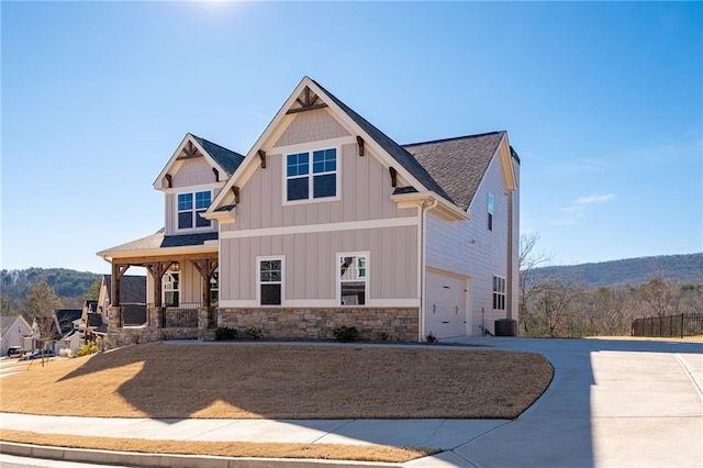 craftsman-style home with cooling unit, a garage, and covered porch