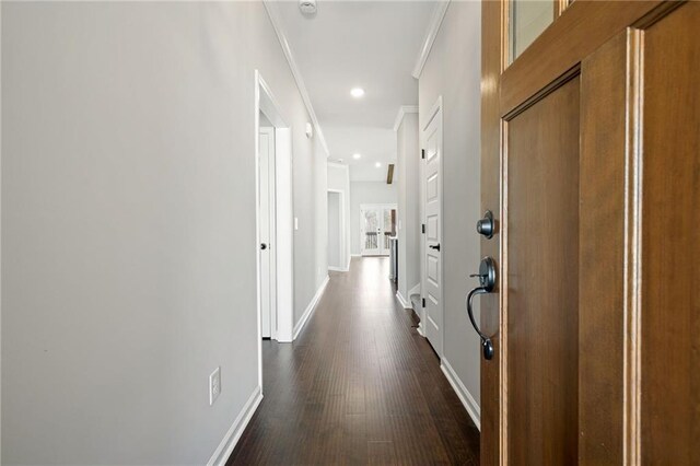 corridor with dark hardwood / wood-style flooring and ornamental molding