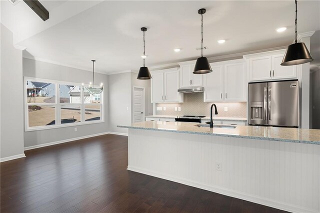 kitchen with sink, light stone counters, tasteful backsplash, stainless steel fridge, and white cabinets