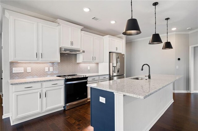 kitchen with appliances with stainless steel finishes, decorative light fixtures, sink, white cabinets, and a kitchen island with sink