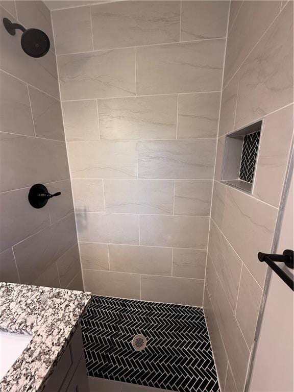 bathroom with vanity and a tile shower