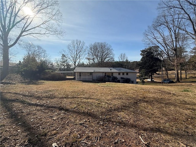 rear view of house featuring a yard