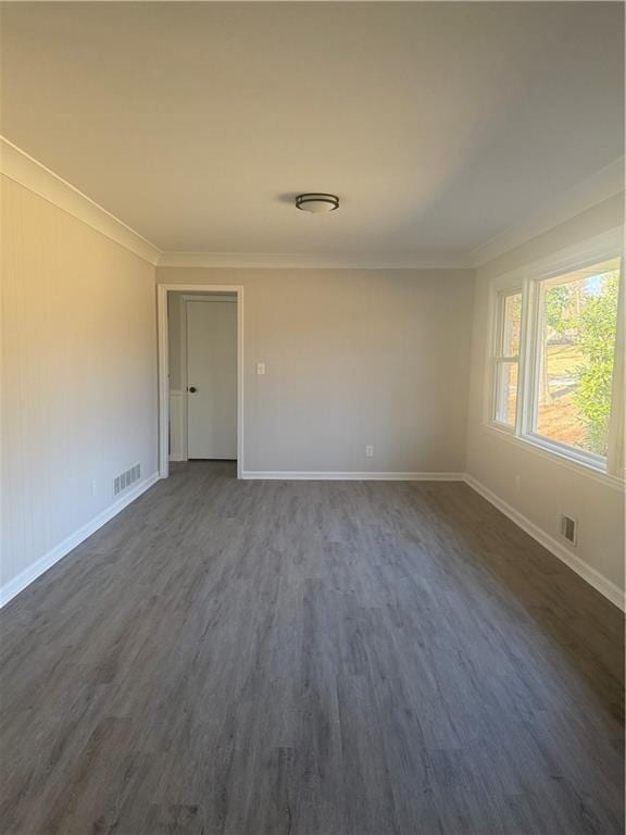 spare room featuring dark hardwood / wood-style flooring and crown molding