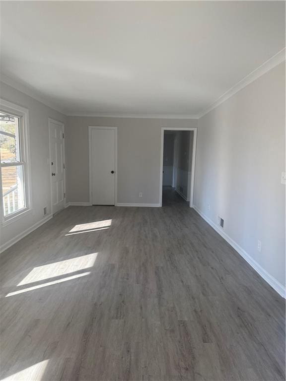 unfurnished room featuring ornamental molding and dark hardwood / wood-style floors