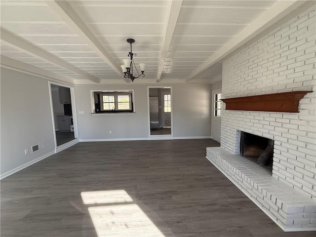 unfurnished living room featuring dark hardwood / wood-style floors, beam ceiling, a chandelier, and a brick fireplace