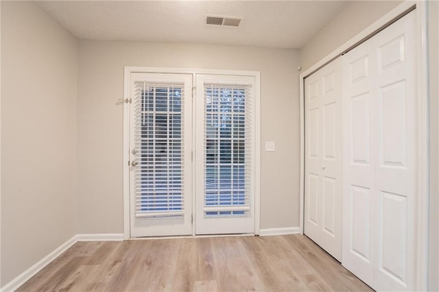 7113 Ambercrest Ct, Austell, GA 30168 - unfurnished bedroom featuring light wood-type flooring, baseboards, access to exterior, and a textured ceiling