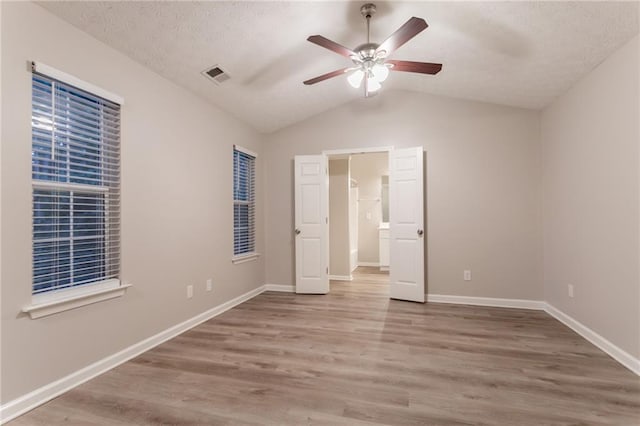 7113 Ambercrest Ct, Austell, GA 30168 - unfurnished bedroom featuring lofted ceiling, wood finished floors, baseboards, a textured ceiling, and a ceiling fan
