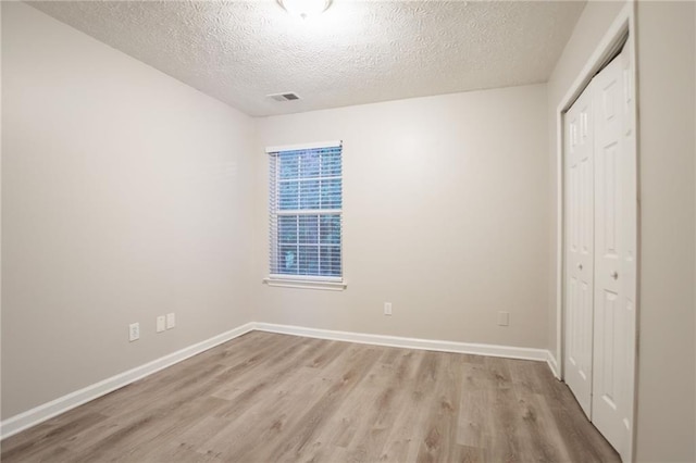 7113 Ambercrest Ct, Austell, GA 30168 - unfurnished bedroom featuring a closet, light wood finished floors, a textured ceiling, and baseboards