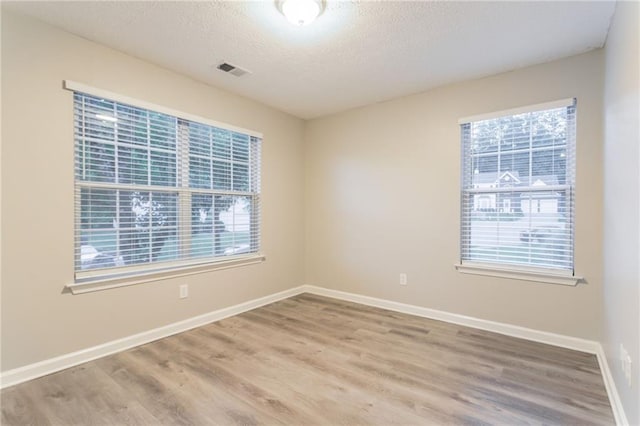 7113 Ambercrest Ct, Austell, GA 30168 - empty room with wood finished floors, a textured ceiling, and baseboards