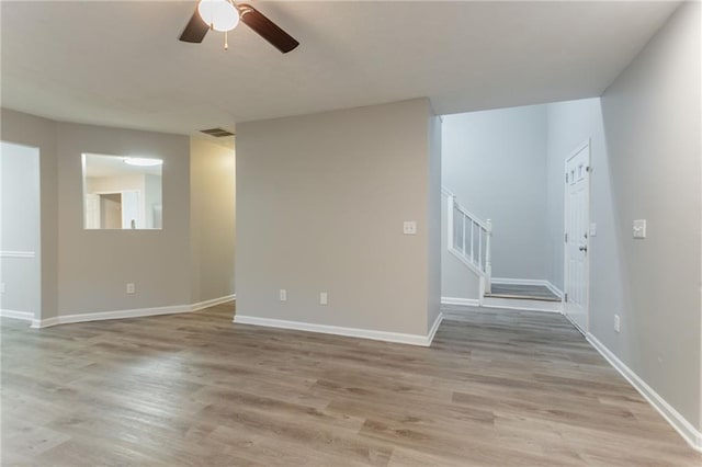 7113 Ambercrest Ct, Austell, GA 30168 - spare room featuring light wood-type flooring, stairway, ceiling fan, and baseboards