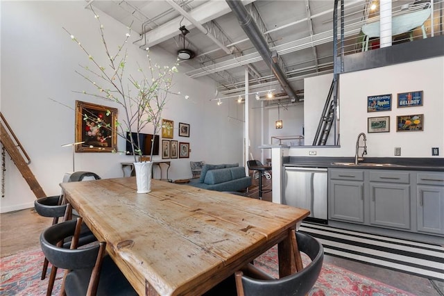 dining space with concrete flooring and a towering ceiling