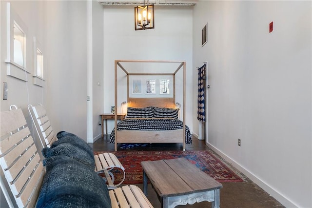 bedroom with visible vents, baseboards, a chandelier, and a towering ceiling