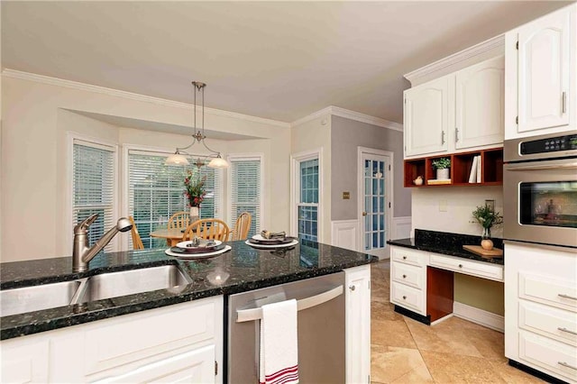 kitchen featuring stainless steel appliances, a sink, white cabinetry, dark stone counters, and crown molding
