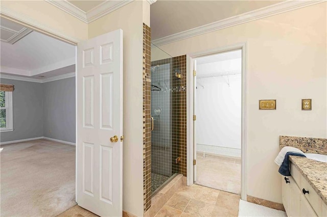 bathroom featuring a shower stall, ornamental molding, vanity, baseboards, and a spacious closet