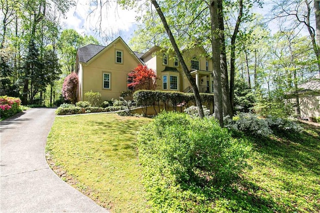 view of home's exterior featuring stucco siding and a lawn