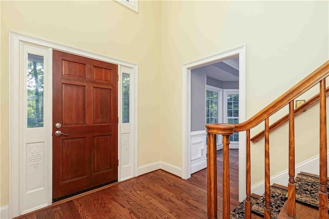 foyer with stairway, wood finished floors, and baseboards