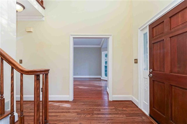 foyer entrance with crown molding, wood finished floors, baseboards, and stairway