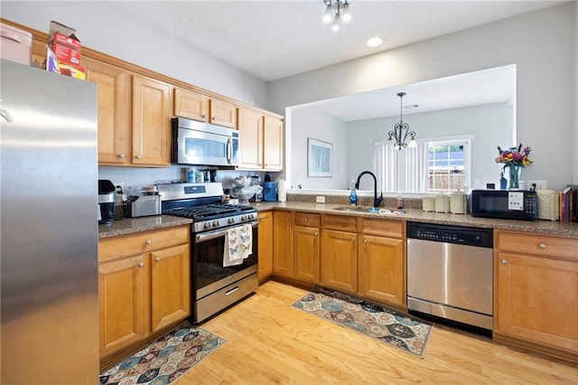 212 Regent Sq, Woodstock, GA 30188 - kitchen featuring light wood-type flooring, a sink, dark stone countertops, and stainless steel appliances