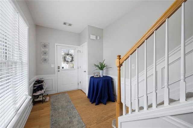 212 Regent Sq, Woodstock, GA 30188 - entrance foyer with visible vents, stairs, wainscoting, and light wood-type flooring