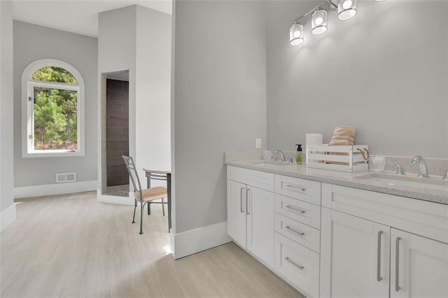 bathroom with a shower, vanity, and hardwood / wood-style flooring