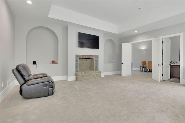 living area featuring a fireplace and light colored carpet