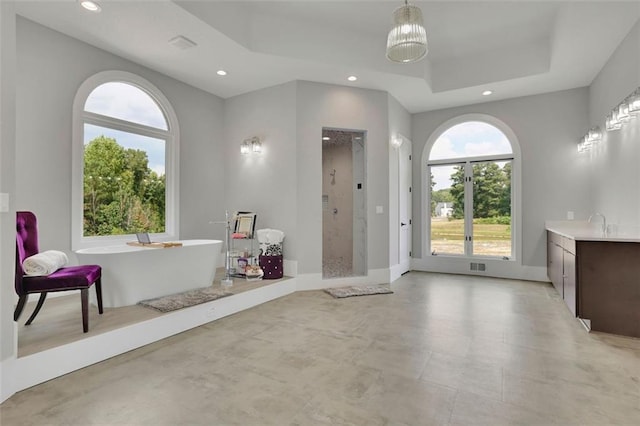 bathroom with vanity, a raised ceiling, and separate shower and tub