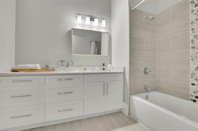 bathroom featuring hardwood / wood-style floors, vanity, and tiled shower / bath