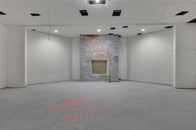 unfurnished living room with concrete floors and a brick fireplace