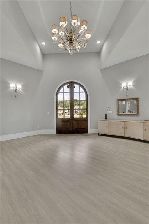 interior space featuring an inviting chandelier, light hardwood / wood-style floors, and french doors