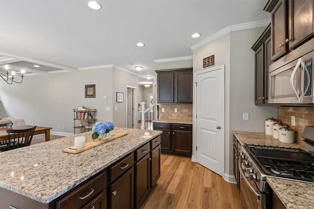 4275 Hunters Walk Way, Cumming, GA 30028 - kitchen featuring appliances with stainless steel finishes, dark brown cabinets, tasteful backsplash, light wood-style floors, and a center island