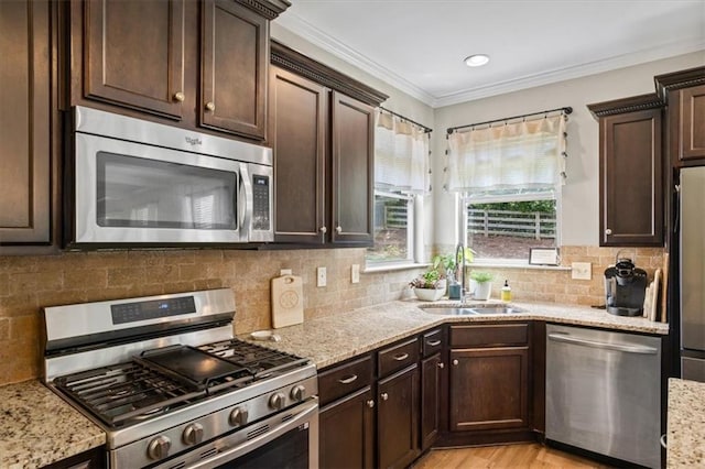 4275 Hunters Walk Way, Cumming, GA 30028 - kitchen with stainless steel appliances, dark brown cabinetry, light stone counters, decorative backsplash, and ornamental molding